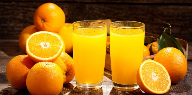 апельсиновый сок в стаканах, рядом лежат апельсины